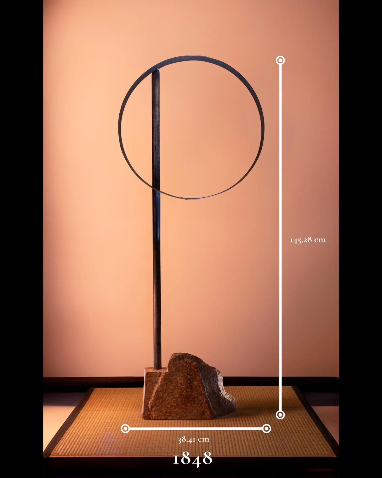 1848, a tall minimalist sculpture composed of a stone base, dark vertical steel support, and circular steel form.